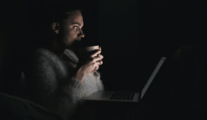 Woman drinking coffee at computer